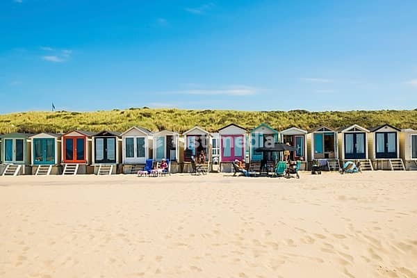 Sandy beach beach with beach huts and blue sky, Wijk aan Zee, North Sea, North Holland, Netherlands