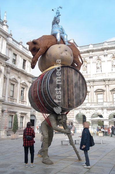 Visitors interact with 'Stack' by Nicole Eisenman, 2022-2024. Made with bronze, oak wood, mineral material, aluminium, and steel and standing at 820 x 335 x 346 cm