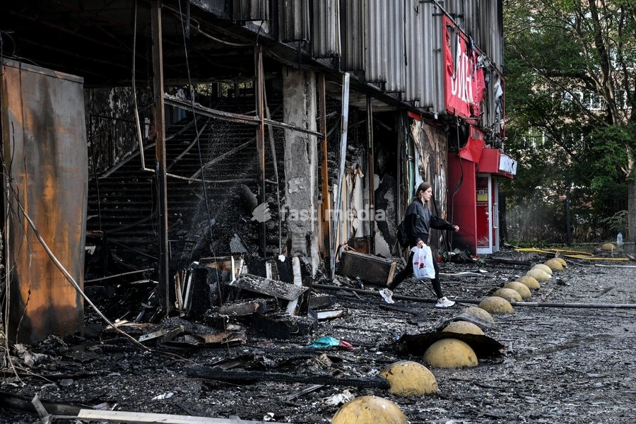 A woman with a bag walks out of the fire-stricken Intrade shopping centre, which burnt down following a Russian drone attack, Zaporizhzhia, Ukraine, September 21, 2026. Overnight, Russian forces struck the city with strike UAVs and an FPV drone. The attack destroyed a shopping centre, damaged a…