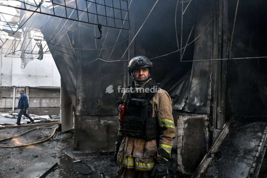 A State Emergency Service rescuer stands in front of damaged retail pavilions after the main hotspots of a fire were extinguished at the Central Clothes Market (Anholenko) in Zaporizhzhia, Ukraine, September 26, 2026. The market sustained significant damage in a Russian drone attack