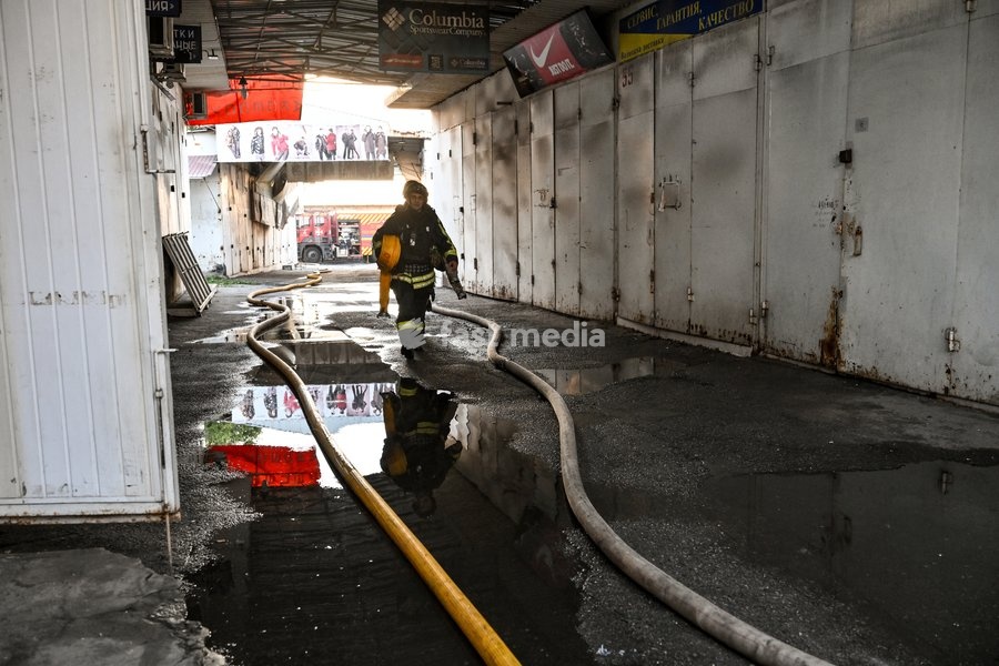 A State Emergency Service rescuer carries a fire hose along a flooded passageway after the main hotspots of a fire were extinguished at the Central Clothes Market (Anholenko) in Zaporizhzhia, Ukraine, September 26, 2026. The market sustained significant damage in a Russian drone attack