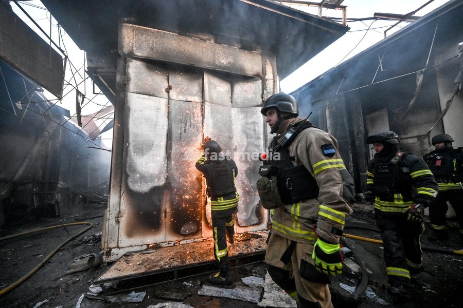 A State Emergency Service rescuer uses a cut-off saw to try to open the deformed metal door of a shipping container while extinguishing a fire at the Central Clothes Market (Anholenko) in Zaporizhzhia, Ukraine, September 26, 2026. The market sustained significant damage in a Russian drone attack