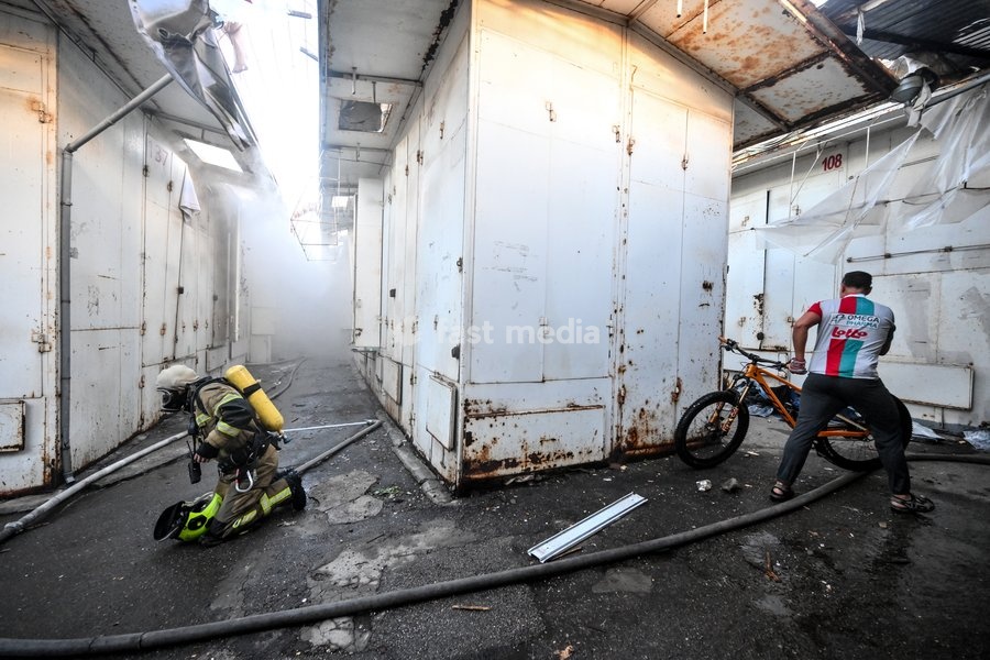 A State Emergency Service rescuer, wearing protective gear with an air tank, works in a smoke-filled passageway to extinguish a fire at the Central Clothes Market (Anholenko) in Zaporizhzhia, Ukraine, September 26, 2026. The market sustained significant damage in a Russian drone attack