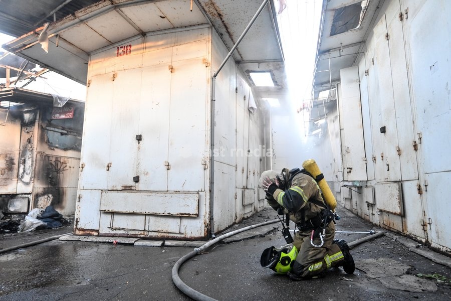 A State Emergency Service rescuer, wearing protective gear with an air tank, works in a smoke-filled passageway to extinguish a fire at the Central Clothes Market (Anholenko) in Zaporizhzhia, Ukraine, September 26, 2026. The market sustained significant damage in a Russian drone attack
