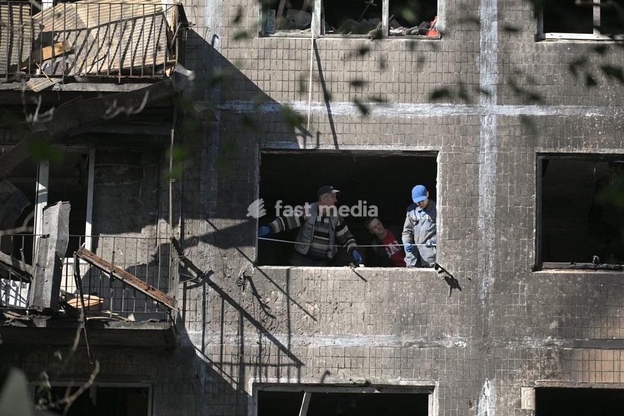 Municipal workers measure dimensions for a board that will replace a window in a five-storey apartment block in the Solomianskyi district, shattered by a Russian drone attack, Kyiv, Ukraine, September 26, 2026. During the morning assault on the capital, a Russian drone exploded close to the…