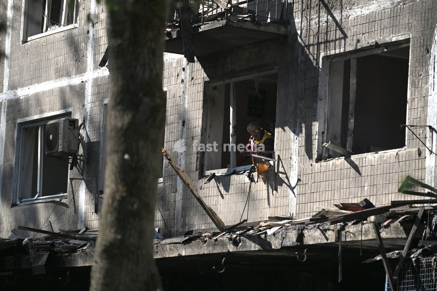A municipal worker stands in a window in a five-storey apartment block in the Solomianskyi district, shattered by a Russian drone attack, Kyiv, Ukraine, September 26, 2026. During the morning assault on the capital, a Russian drone exploded close to the residential building. A fire covering 400…