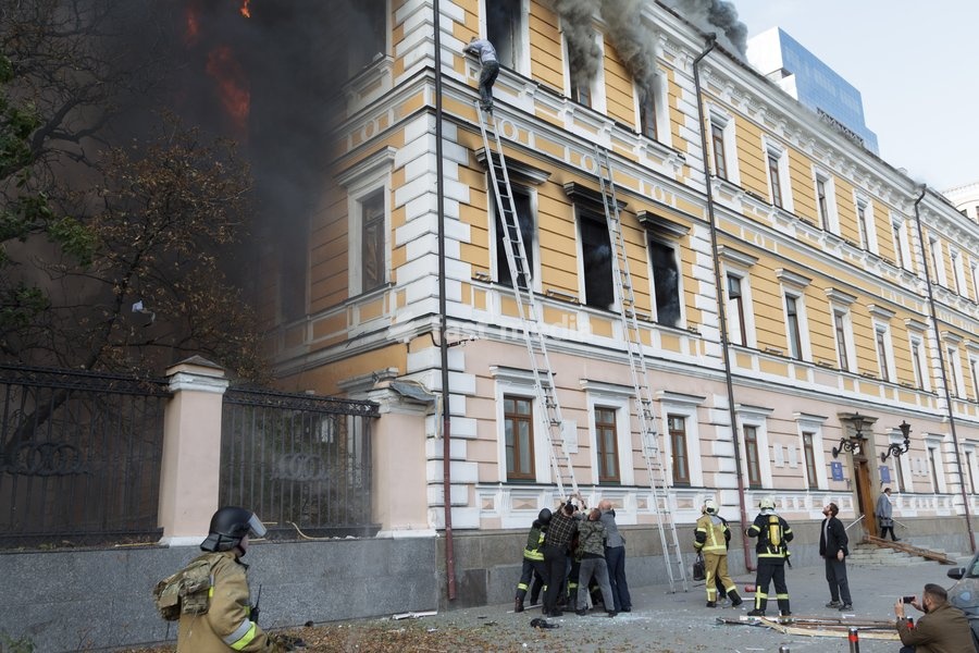 A man goes down a telescopic ladder to escape from the National Academy of Sciences building, which is engulfed in flames after being hit by a Russian drone, in Kyiv, Ukraine, September 28, 2026. One person was killed, and three others were injured in the attack