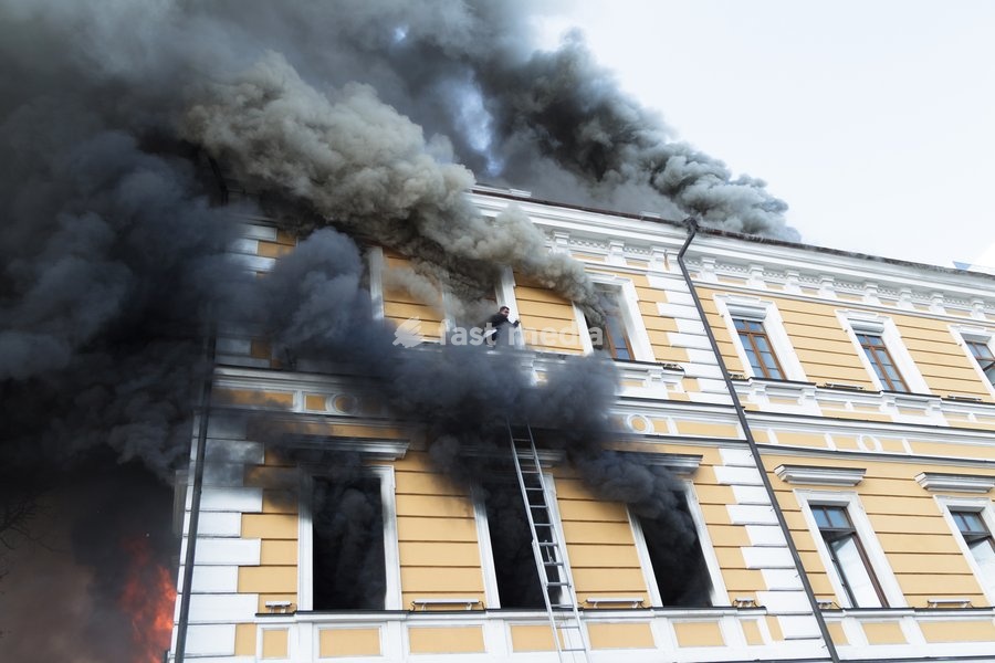 A man tries to reach a telescopic ladder as he attempts to escape from the National Academy of Sciences building, which is engulfed in flames after being hit by a Russian drone, in Kyiv, Ukraine, September 28, 2026. One person was killed, and three others were injured in the attack