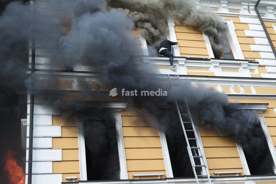 A man tries to reach a telescopic ladder as he attempts to escape from the National Academy of Sciences building, which is engulfed in flames after being hit by a Russian drone, in Kyiv, Ukraine, September 28, 2026. One person was killed, and three others were injured in the attack