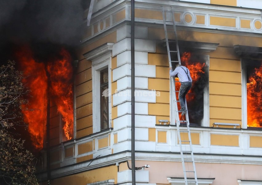 A man goes down a telescopic ladder to escape from the National Academy of Sciences building, which is engulfed in flames after being hit by a Russian drone, Kyiv, Ukraine, September 28, 2026. One person was killed, and three others were injured in the attack
