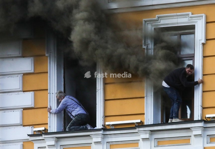 Two men attempt to escape from the National Academy of Sciences building, which is engulfed in flames after being hit by a Russian drone, Kyiv, Ukraine, September 28, 2026. One person was killed, and three others were injured in the attack
