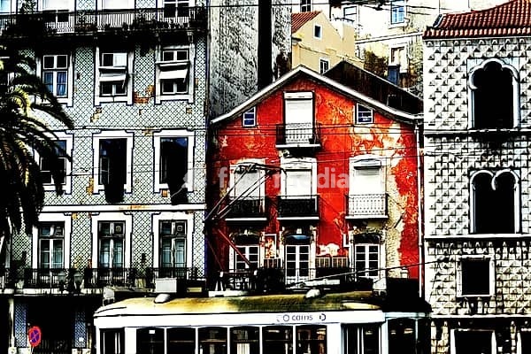 Traditional vintage tram moving past colorful, historic architecture in Lisbon city center