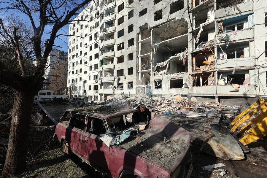 A man stands next to a damaged car near a multi-storey residential building hit by a Russian glide bomb in Kharkiv, Ukraine, on September 28, 2026. Russian forces launched glide bomb strikes on the Kyivskyi and Saltivskyi districts of Kharkiv, with one bomb hitting the apartment building. More than…
