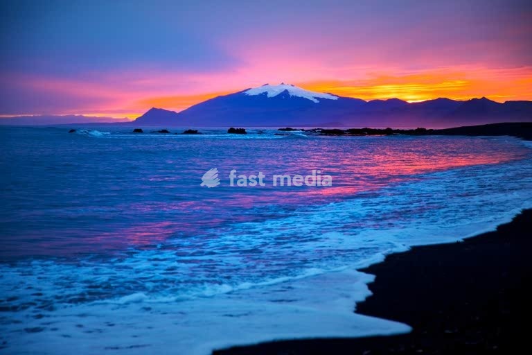 Strand mit Meeresbrandung und dem Snæfellsjoekull mit farbintensivem Sonnenuntergang hinter dem Gletscher, Langaholt, Snæfellsnes, Island, Europa