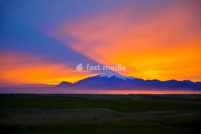 Snæfellsjoekull mit sehr farbintensivem und atmosphaerischem Sonnenuntergang hinter dem Vulkan und Gletscher, Langaholt, Snæfellsnes, Island, Nordeuropa
