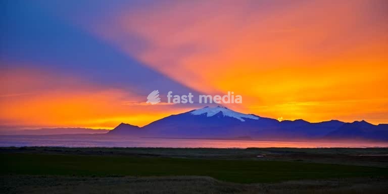 Snæfellsjoekull mit sehr farbintensivem und atmosphaerischem Sonnenuntergang hinter dem Vulkan und Gletscher, Langaholt, Snæfellsnes, Island, Nordeuropa