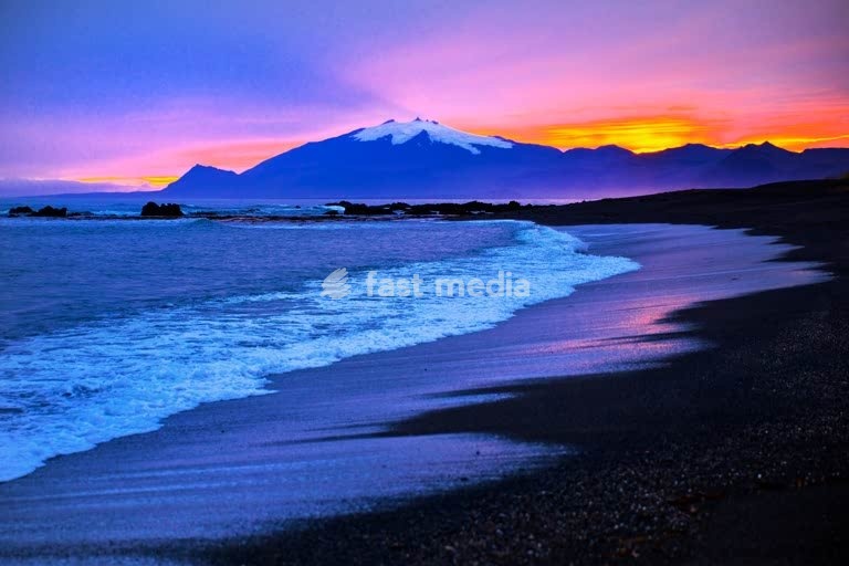 Strand mit Meeresbrandung und dem Snæfellsjoekull mit farbintensivem Sonnenuntergang hinter dem Gletscher, Langaholt, Snæfellsnes, Island, Europa