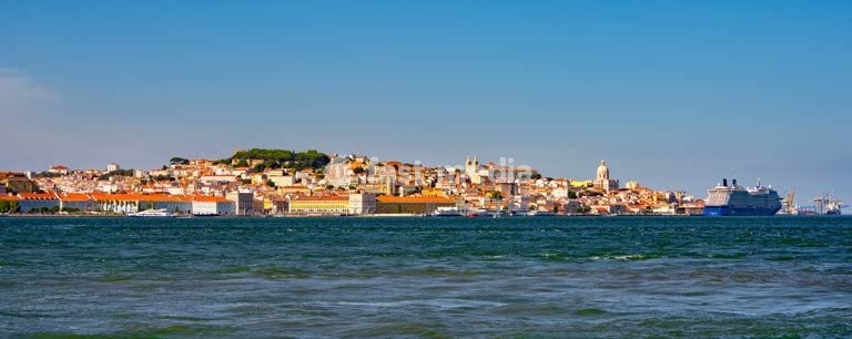 Lisbon cityscape with Praça do Comércio, Tagus River, Sé Cathedral and São Jorge Castle on the hillside, showcasing colorful historic architecture