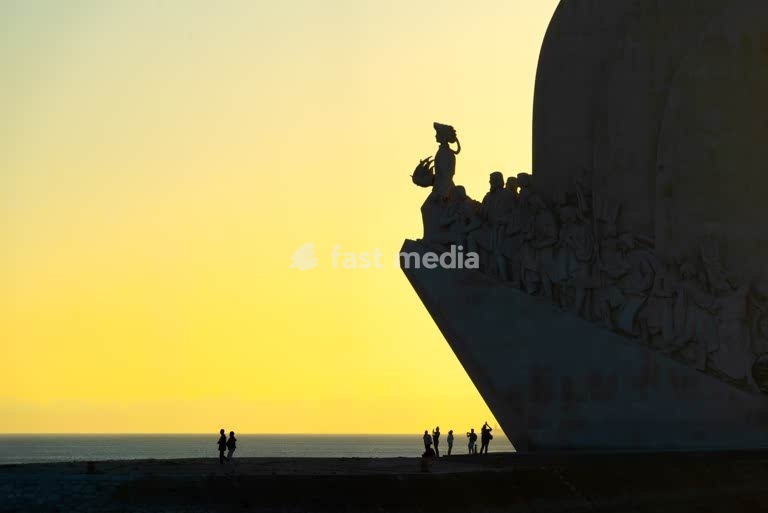 Silhouetted Monument to Discoveries at sunset along Tagus River waterfront in Belém Lisbon