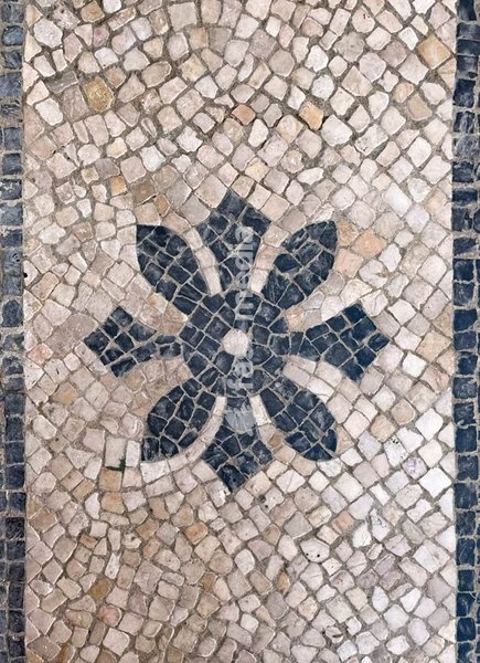 Lisbon, Portugal – Pavement calçada portuguesa with floral rosette in basalt and limestone stones