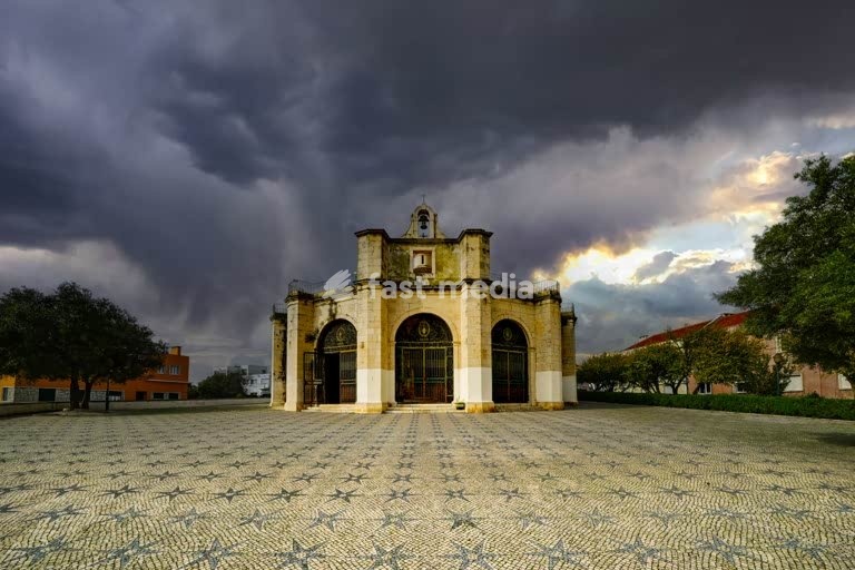 Lisboa, Portugal – Capela de Santo Amaro sob nuvens de tempestade e luz dramática da tarde