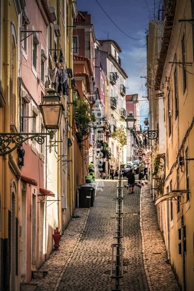 Narrow cobblestone street in Alfama, Lisbon, Portugal, colorful houses and hanging laundry