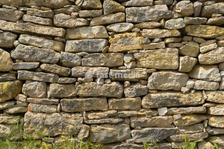 Traditional dry-stone wall with weathered rocks in a rural landscape