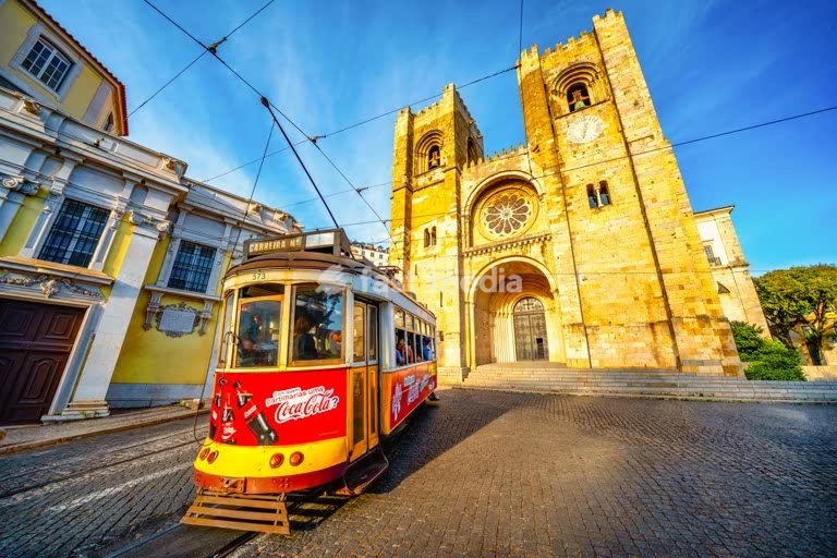Lisbon, Portugal – Yellow tram passing Lisbon Cathedral in bright afternoon light. Photo Peter Delius