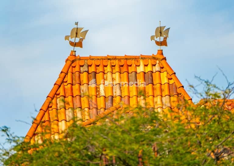 Lisbon, Portugal – Twin weather vanes in the shape of 16th century caravels atop a terracotta roof in Belém, Lisbon