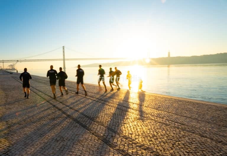 Morning runners silhouette at 25 de Abril Bridge, Tagus River sunrise – Lisbon Alcantara Portugal modern vibe