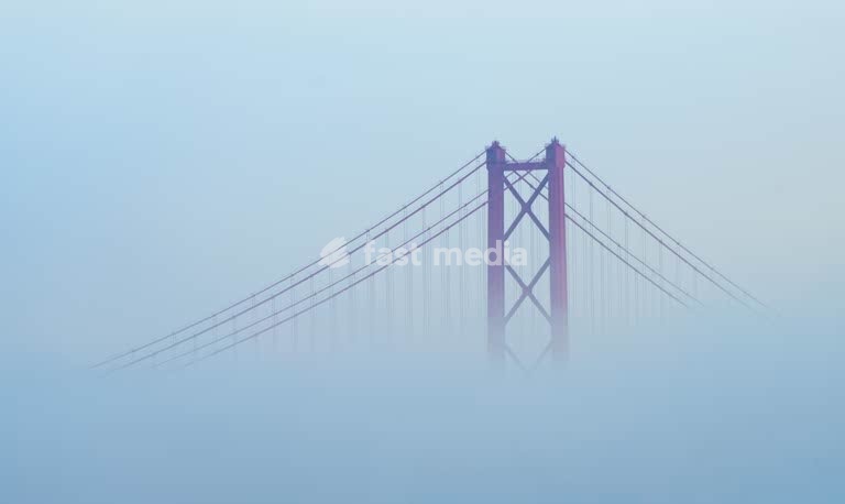 25 de Abril Bridge tower in morning fog, Tagus River Lisbon Portugal – moody minimalist detail