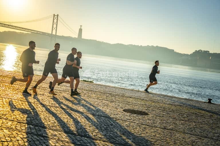 Morning runners silhouette at 25 de Abril Bridge, Tagus River sunrise – Lisbon Alcantara Portugal modern vibe