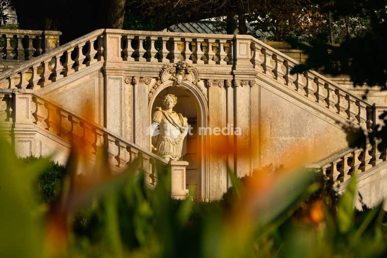 Statue in staircase niche framed by autumn foliage, Jardim Botânico da Ajuda, Lisbon