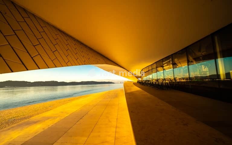 Undulating tiled canopy of MAAT with river view at golden hour, Lisbon, Portugal