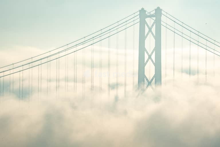 25 de Abril Bridge tower in morning fog, Tagus River Lisbon Portugal – moody minimalist detail