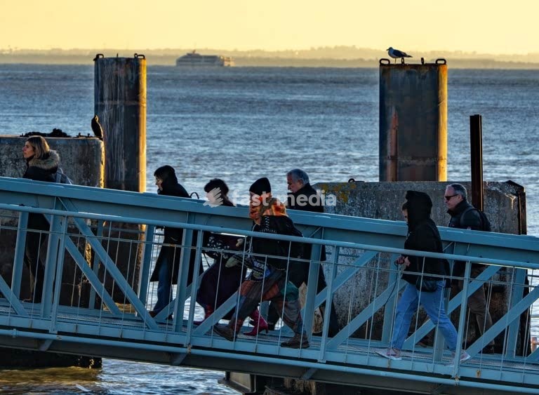 Commuters cross ferry pontoon at sunrise, Belém riverside, Tagus river, Lisbon