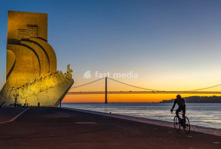 Cyclist silhouette at River Tagus, 25 de Abril Bridge sunrise Lisbon Portugal cool modern mood