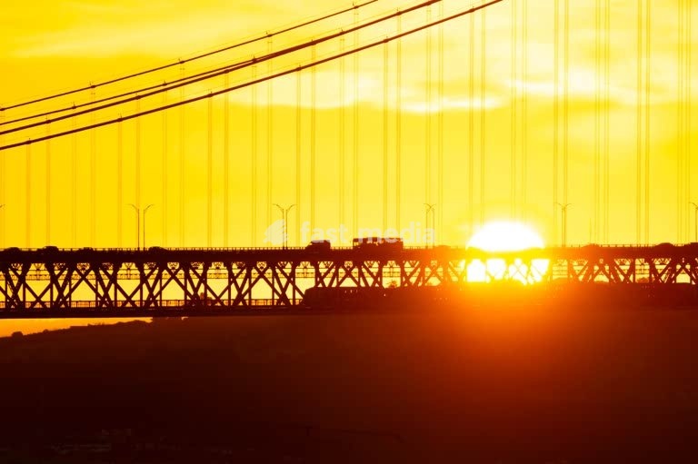 Sunrise silhouette of Ponte 25 de Abril suspension bridge over the Tagus, Lisbon, Portugal