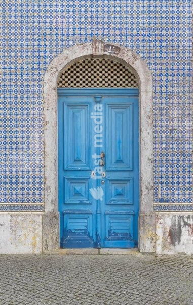 Blue wooden door with arched azulejo tiled facade, historic entrance, Lisbon, Portugal