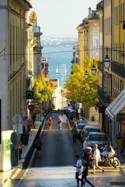 Lisbon Chiado street view to Tagus river, tourists in sunny hillside Lisbon Portugal