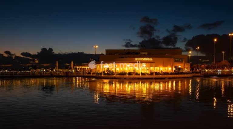 Cosy Portugália restaurant illuminated at night, marina reflections, blue hour, Belém, Lisbon, Portugal