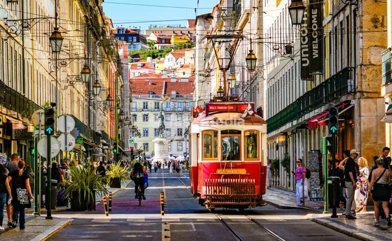 Iconic tram on bustling Rua Augusta with Praça de Figueira beyond, Baixa, Lisbon, Portugal