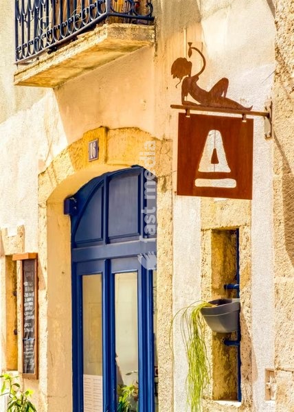 Rustic fish restaurant with iron siren sign and blue arched door, Bairro Alto, Lisbon, Portugal