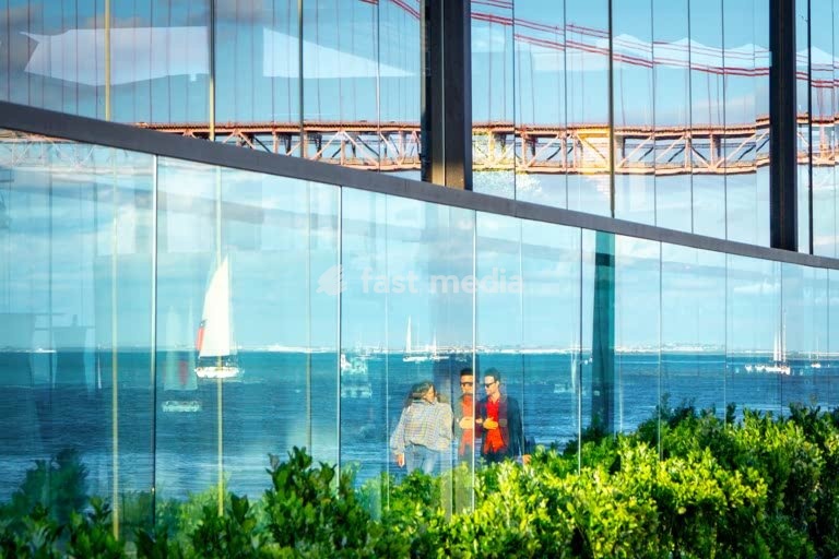 Bridge, sailboat & couple reflected in glass facade, Tagus River, Lisbon, Portugal – creative street photography