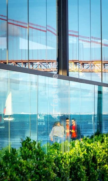 Bridge, sailboat & couple reflected in glass facade, Tagus River, Lisbon, Portugal – creative street photography