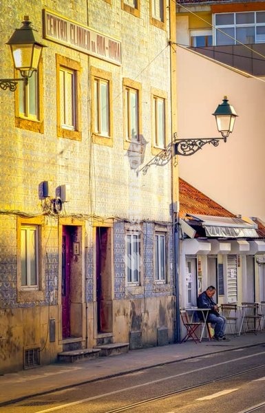 A man in front of a small restaurant in Boa Hora, Lisbon, Portugal
