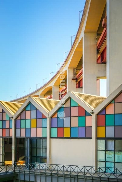 Colorful grid facade of Alcântara Market underneath 25th of April bridge, Lisbon, Portugal