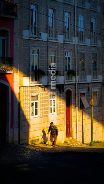 An old man caught in dramatic shaft of light, Lisbon, Portugal