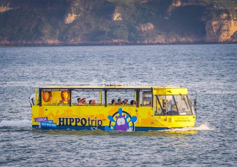 Yellow amphibious Hippotrip bus cruises Tagus River with tourists, Lisbon, Portugal