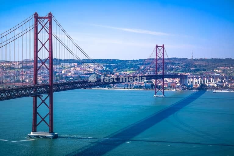25 de Abril Bridge spans the Tagus River, Lisbon, Portugal, suspension bridge over turquoise water